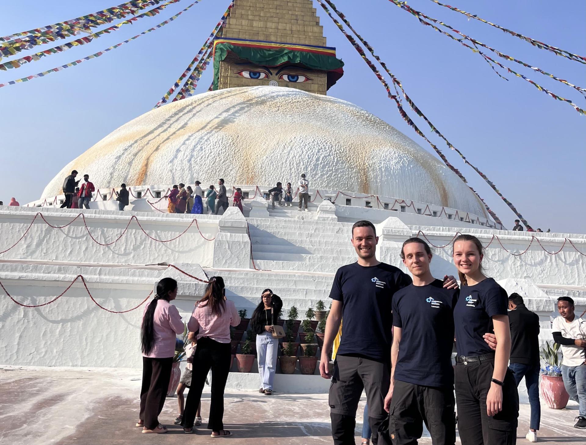 Die 3 Ausreisenden stehen Arm in Arm vor einer Buddha Stupa