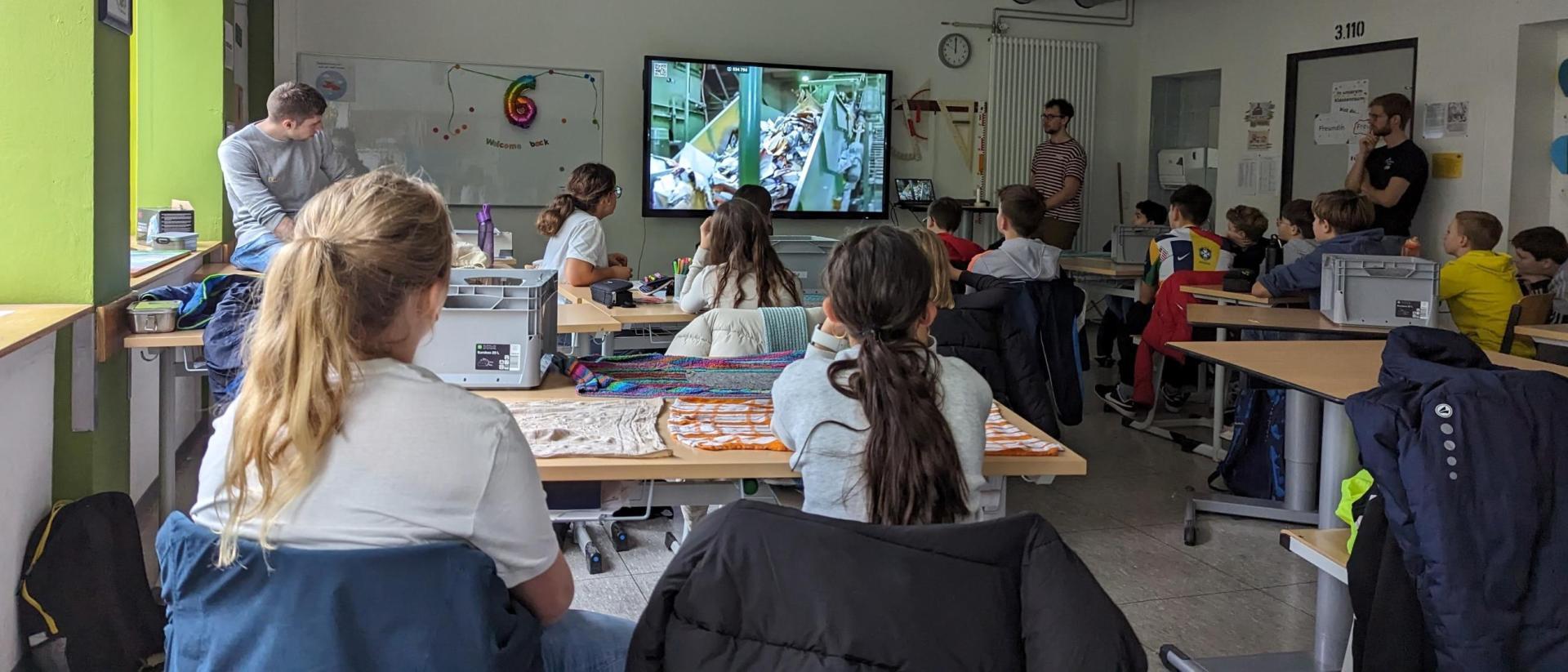 kinder schauen ein Video zum Thema Recycling
