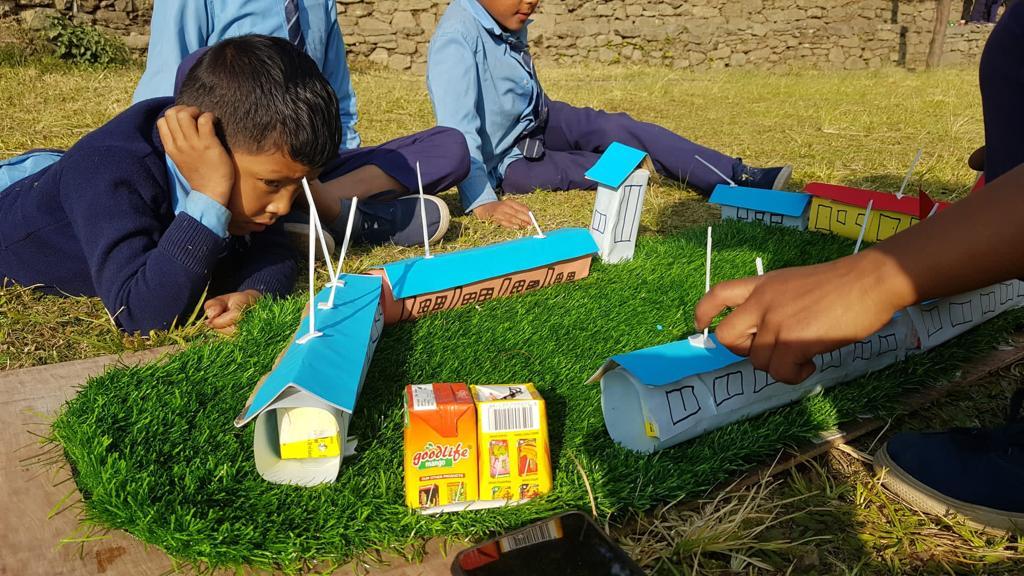 Kinder beobachten gebastelte Schule