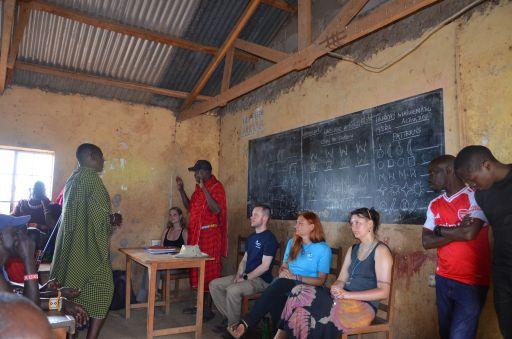 Mitglieder von Ingenieure ohne Grenzen tauschen sich gemeinsam mit Lehrkräften und Vertretern der Maasai-Community in einem Klassenraum aus. Der Besuch diente der Analyse von Bildungsinfrastruktur und schulischen Rahmenbedingungen in der Region.