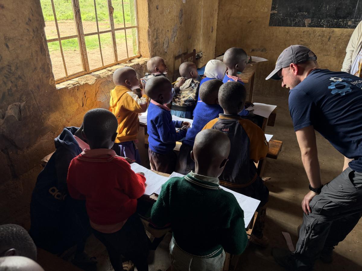 Schülerinnen und Schüler sitzen in einem Klassenraum während des Unterrichts. Ein Mitglied von Ingenieure ohne Grenzen beobachtet die Lernsituation, um die Perspektiven und Bedürfnisse der Kinder besser kennenzulernen.