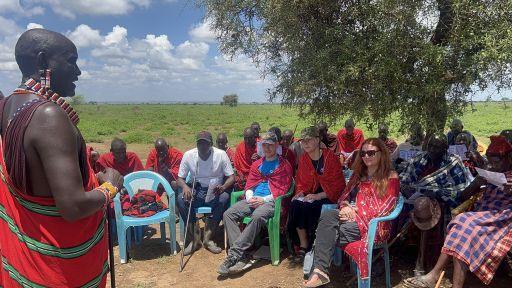 Mitglieder der Maasai-Community und das Projektteam von Ingenieure ohne Grenzen nehmen an einer Versammlung im Freien teil. Gemeinsam werden die zukünftige Entwicklung der Schule und weitere Projektschritte diskutiert.
