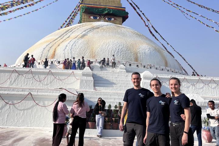 Die 3 Ausreisenden stehen Arm in Arm vor einer Buddha Stupa