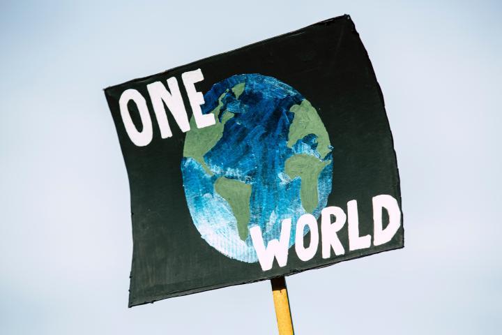 Schild mit Aufschrift "One World"