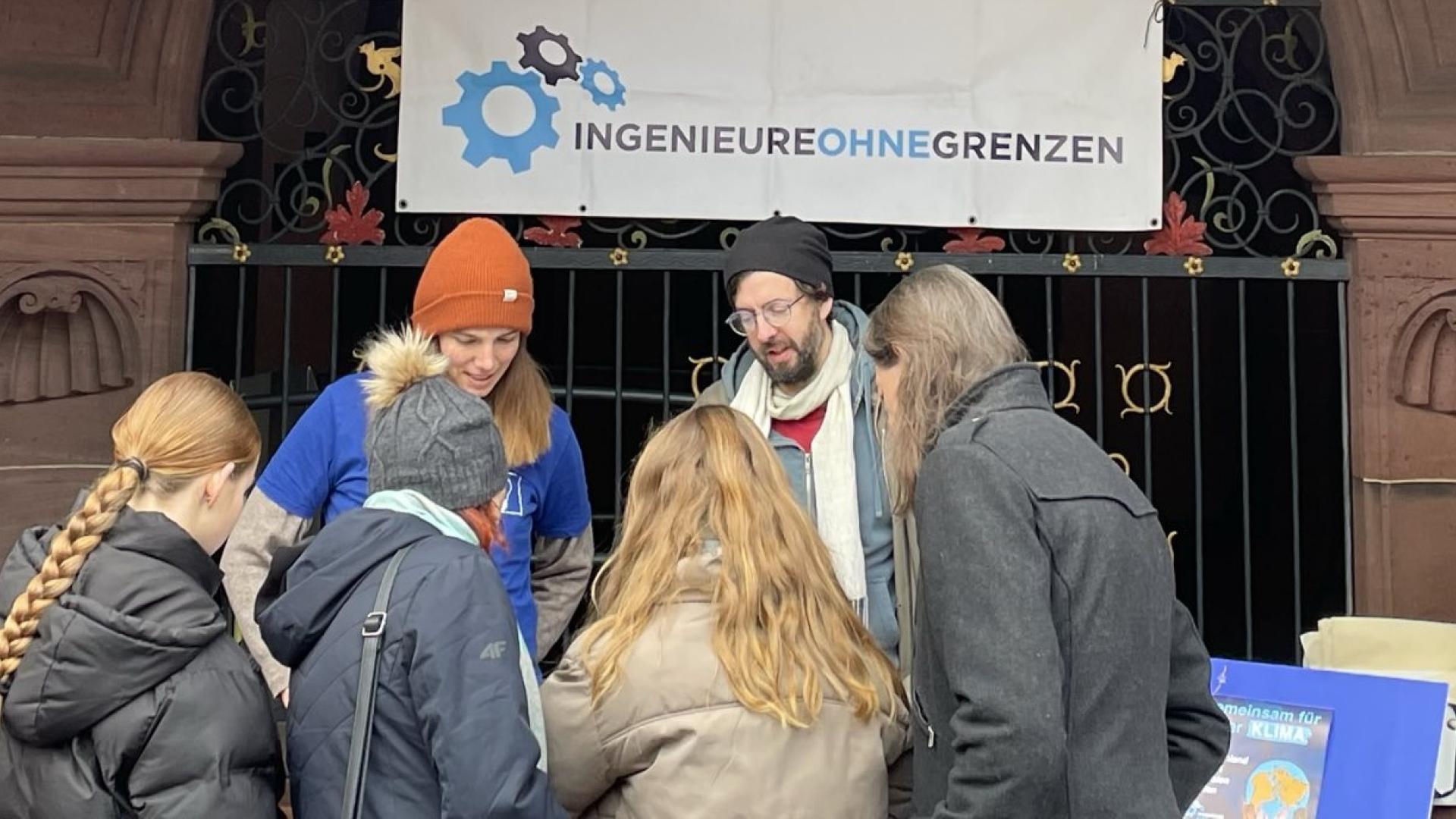 6 Leute schauen gemeinsam etwas an