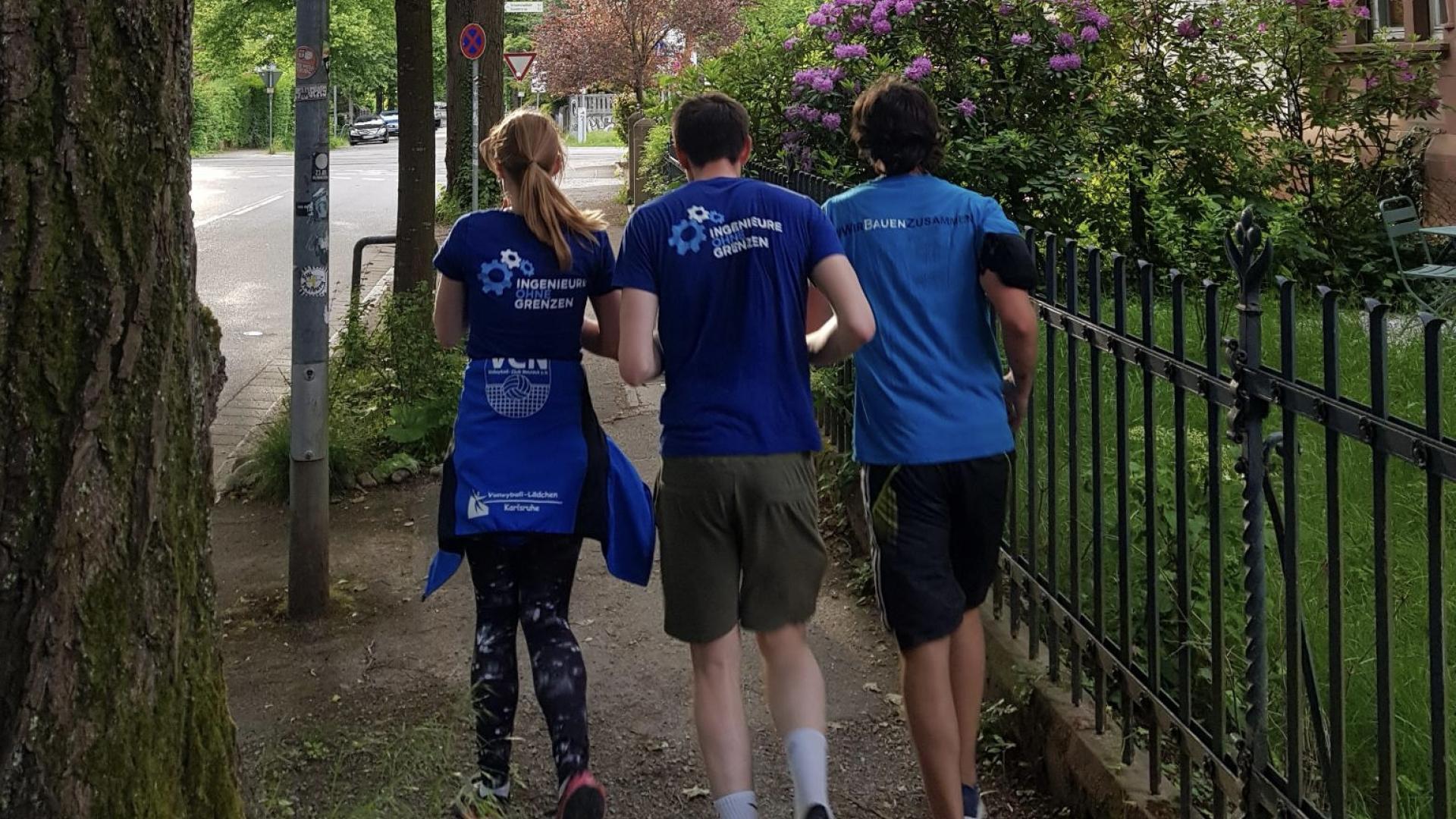 3 Läufer rennen gemeinsam auf dem Gehweg