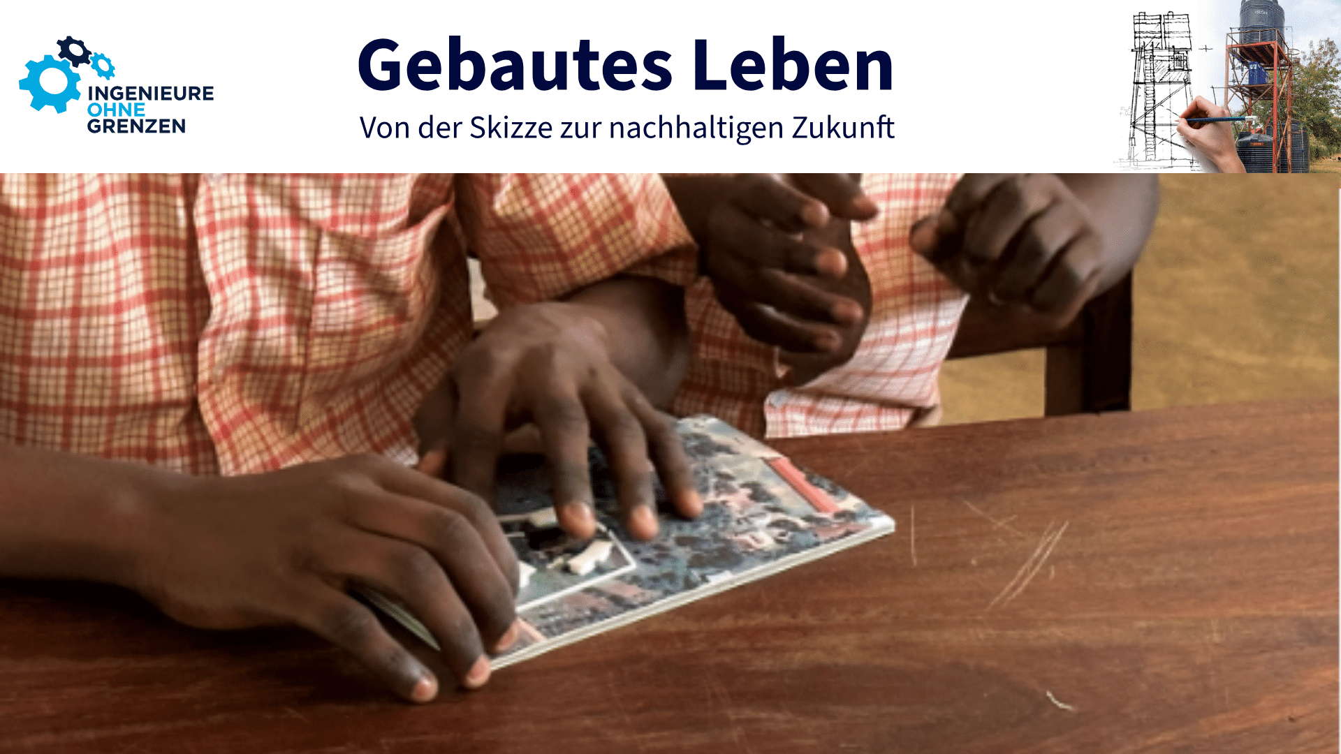 Das Bild zeigt zwei Handpaare, die durch ein Braille-Model, was auf einem Tisch liegt, das Modell für ihre neue Schule ertasten, die gebaut werden soll